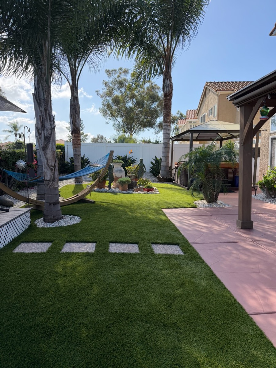 Backyard turf with palm trees, stepping stones, and pergola in North County San Diego