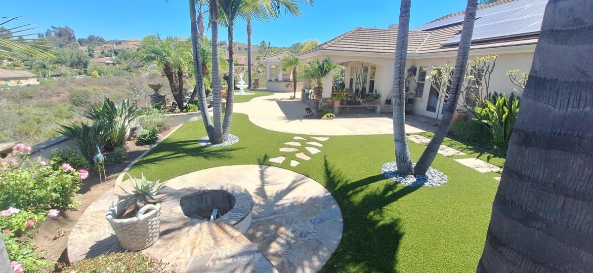 Front courtyard artificial turf with fire pit, palm trees, and flagstone in North County San Diego