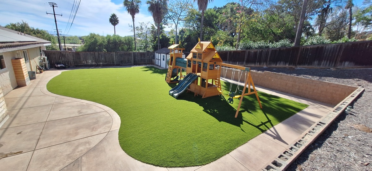 Wide view of playground turf installation with safety surface in Vista